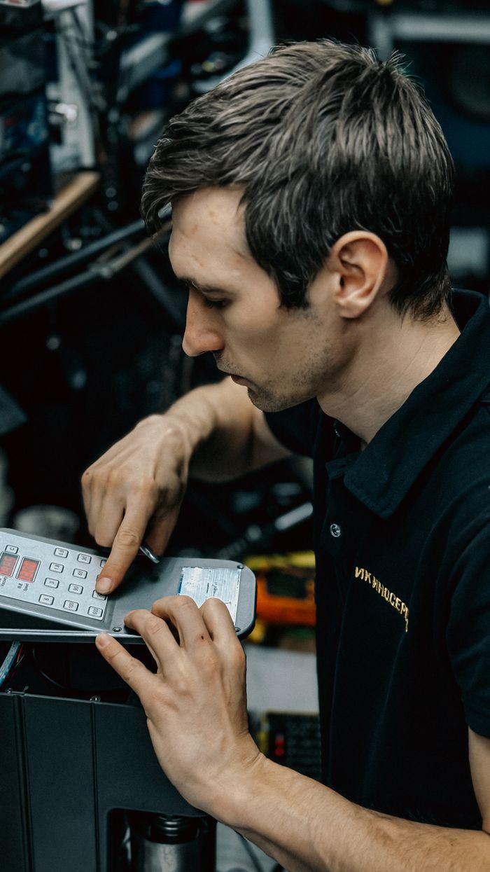 service-04 Professional technician fixing office equipment, focusing on control panel. Perfect for business and technology themes.