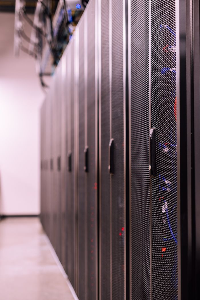 our-stories Row of similar lockers with various optic fiber cables in modern data server room